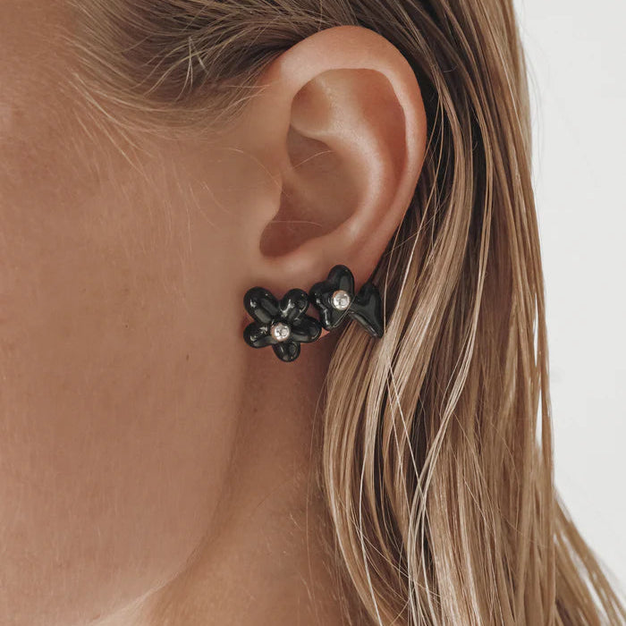 Black flower-shaped earrings on a white background