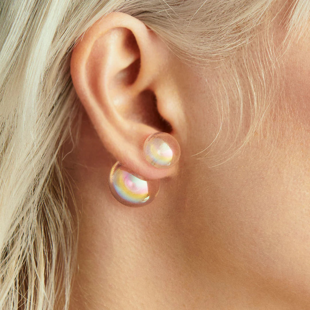 Single stud double-sided earring pearl earrings, one slightly larger than the other, on a light gray background