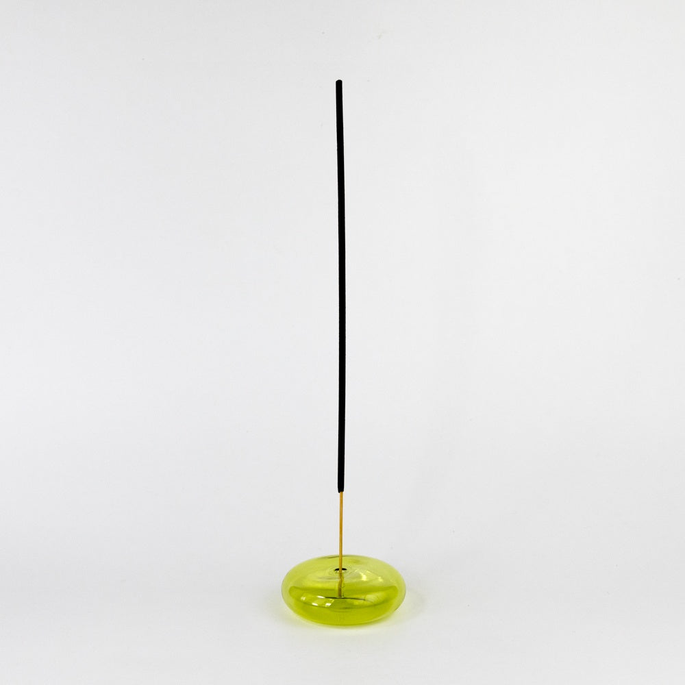 Incense stick in a green holder on a white background