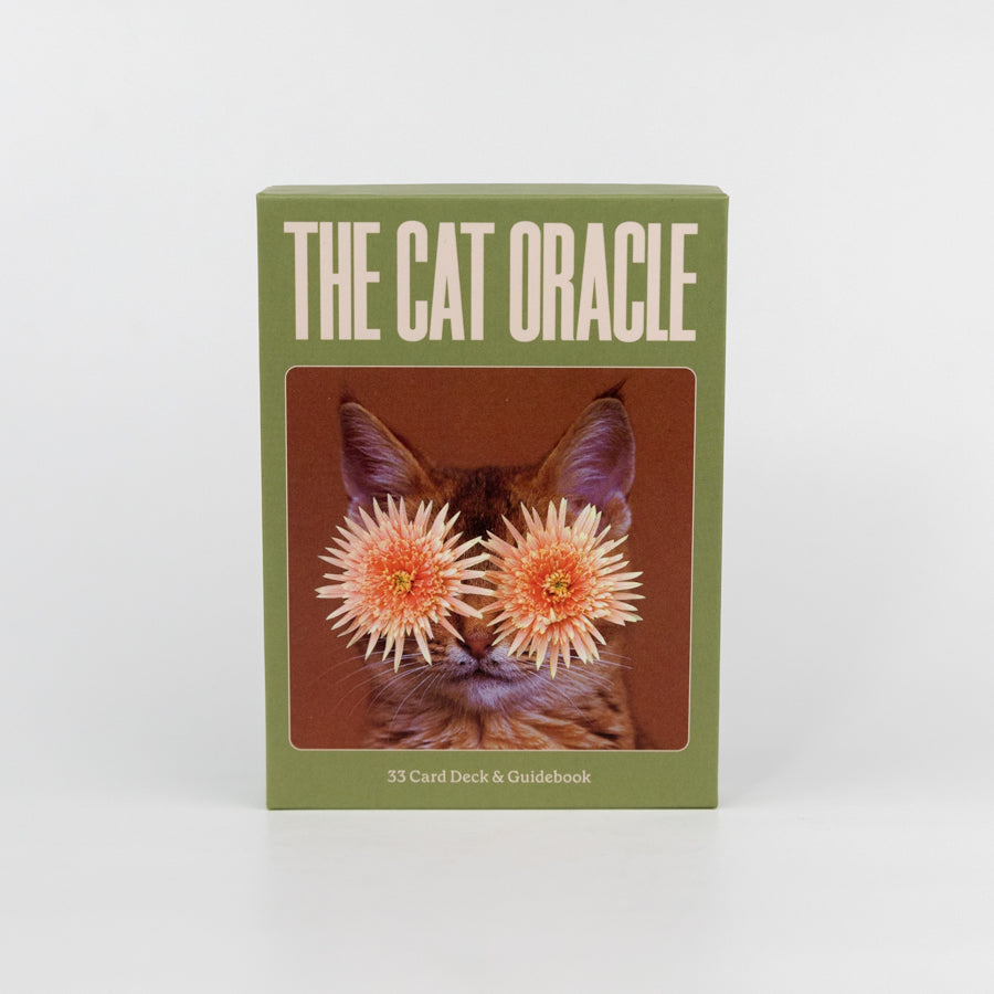 Card deck packaging titled 'The Cat Oracle' with a cat's face with flowers for eyes on a green background.