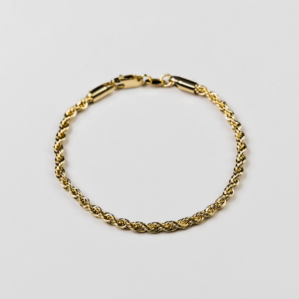 Gold bracelet on a light gray background