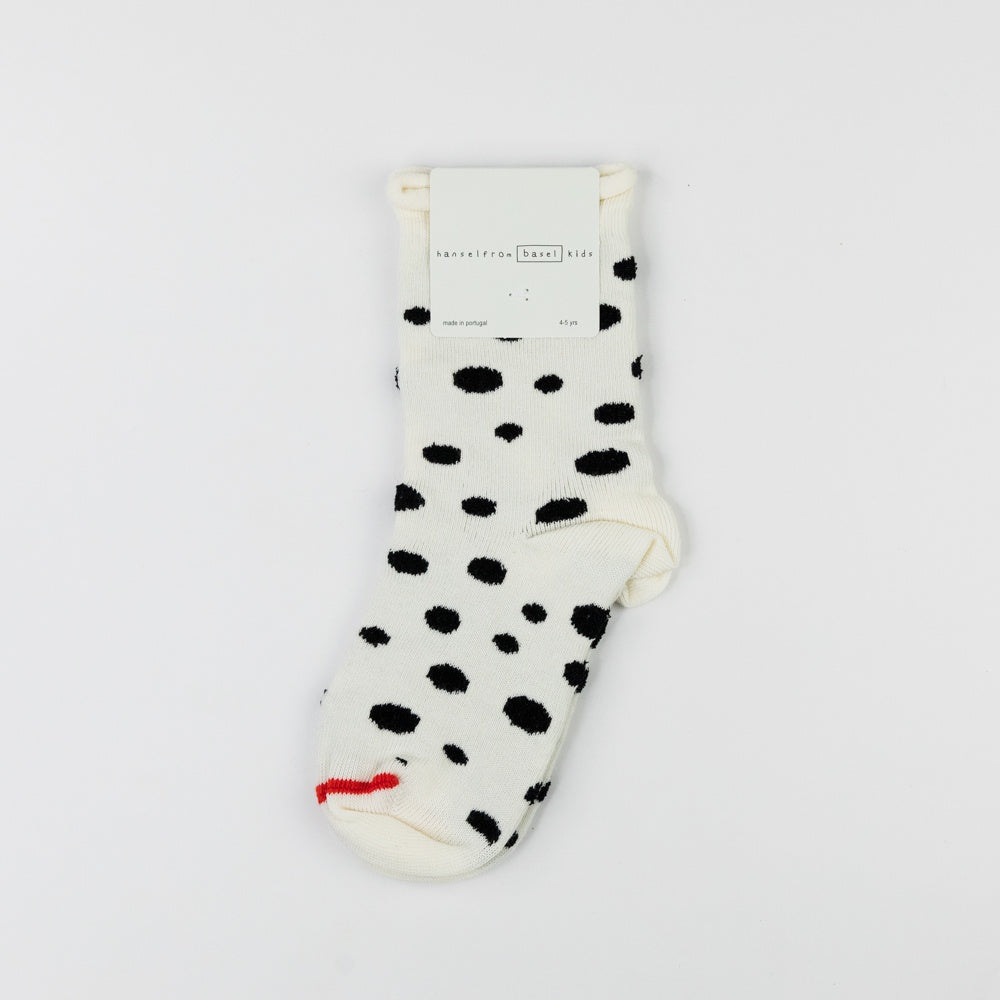 White sock with black polka dots on a white background