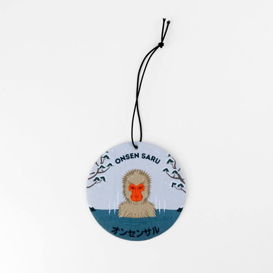 Round hanging flat disc with a monkey illustration and text on a white background