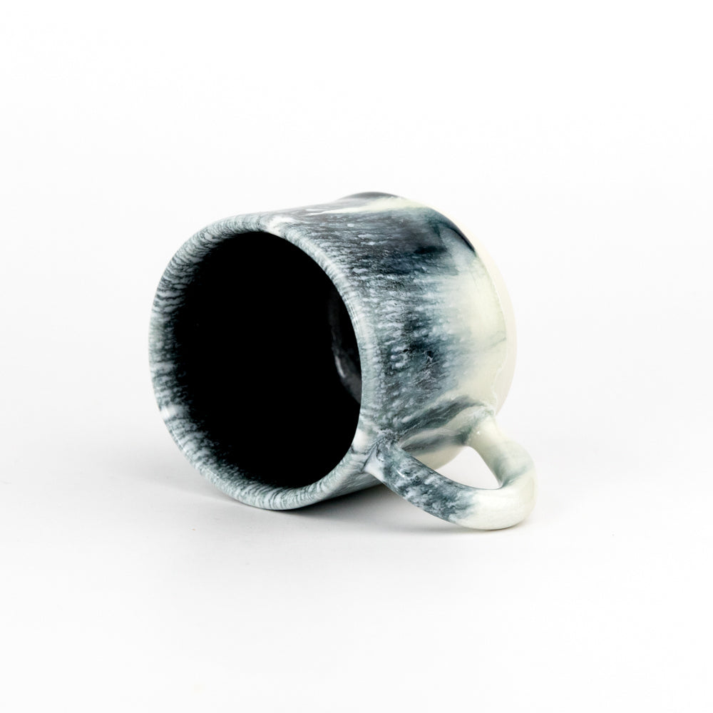 Ceramic mug with black to white gradient on a white background