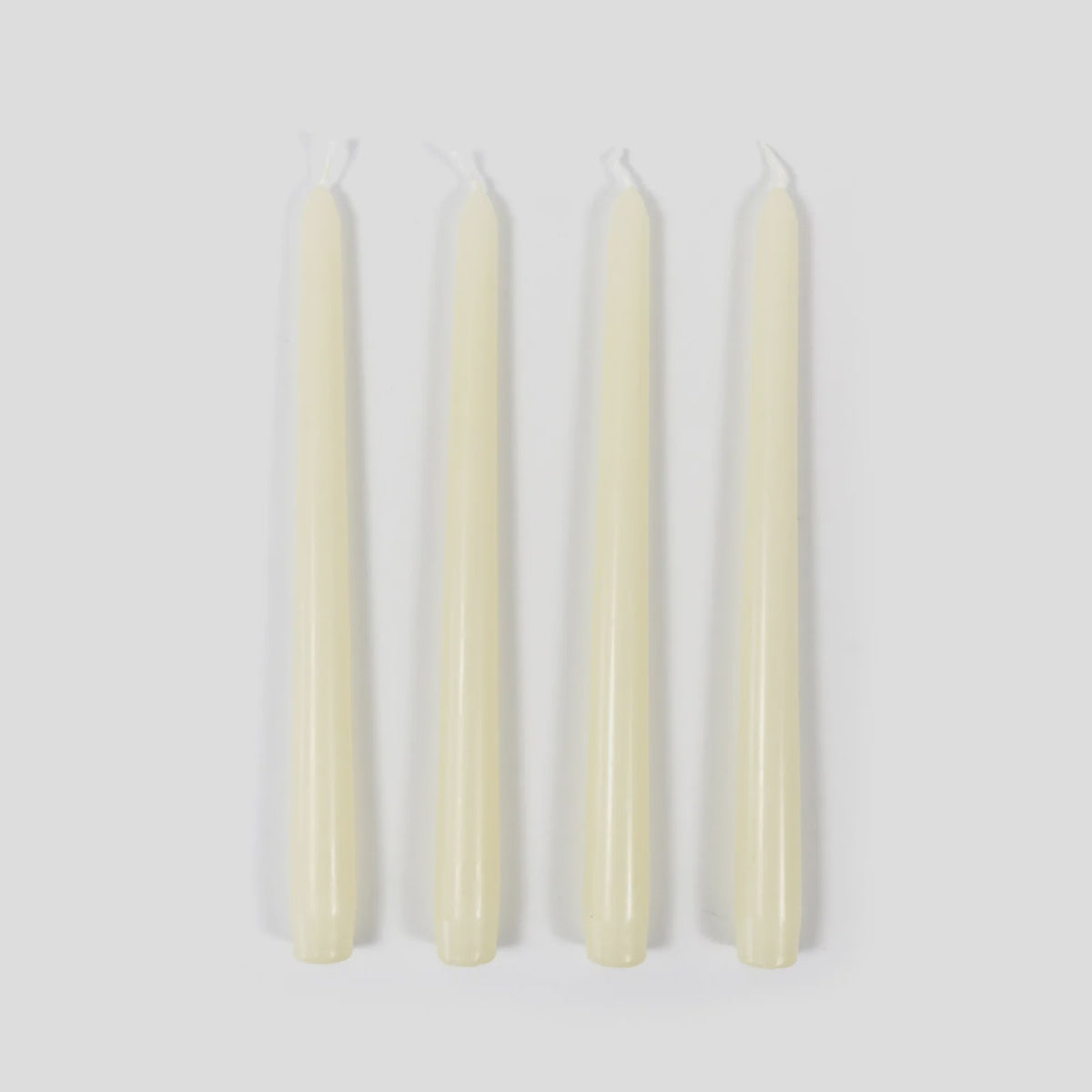 Four white candles on a light gray background