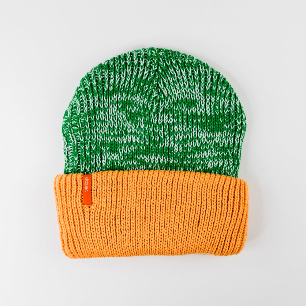 Green and orange knit beanie on a light gray background