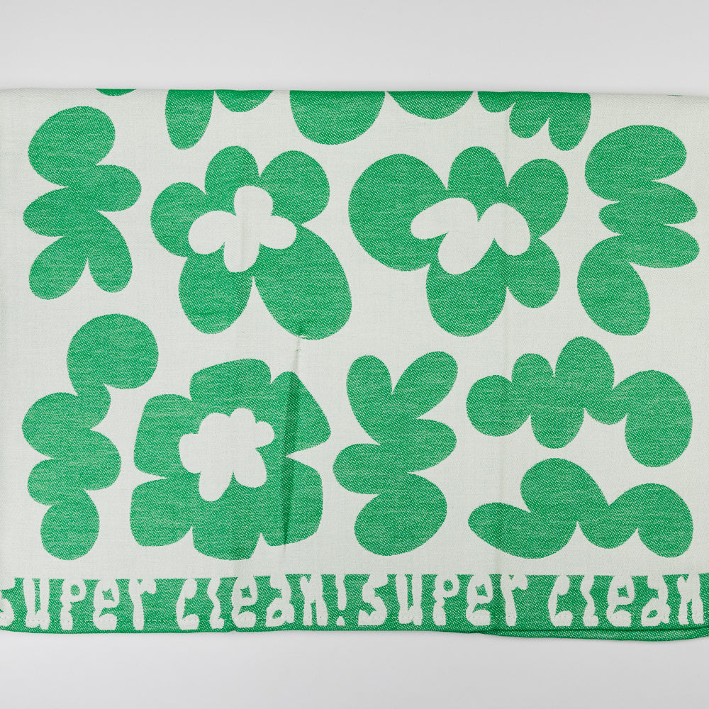 Green and white floral patterned towel with 'Super Clean Flowers' text on a light gray background