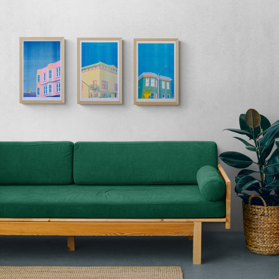 SF Corner Risograph Print is a florescent  pink and orange building with a blue sky backdrop 